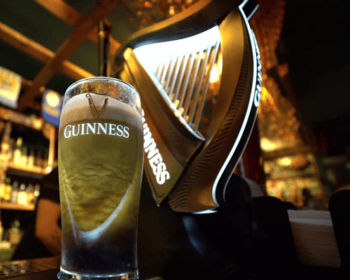 Frissen csapolt Guinness pohár a csapoló előtt